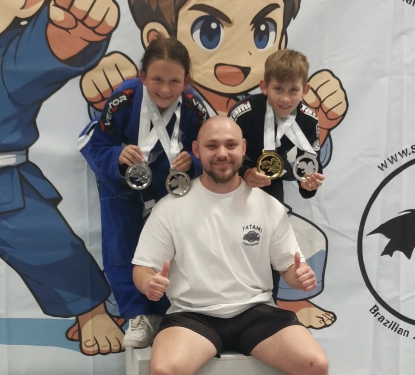 Kinder des Martial Arts Sports Center Grünstadt mit Trainer beim Dragon Cup 2026 nach erfolgreichen Wettkämpfen im Brazilian Jiu Jitsu und Grappling.